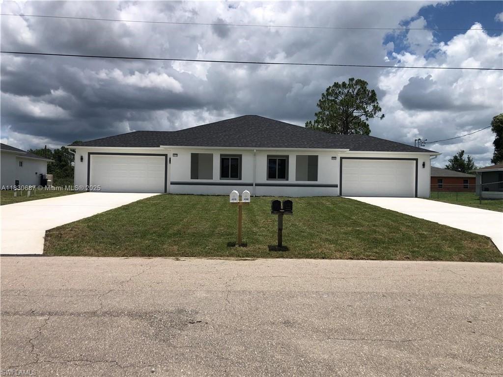 Ranch-style home featuring a front yard, roof with shingles, and driveway