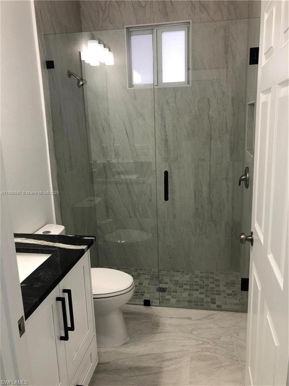Full bath featuring vanity and a marble finish shower