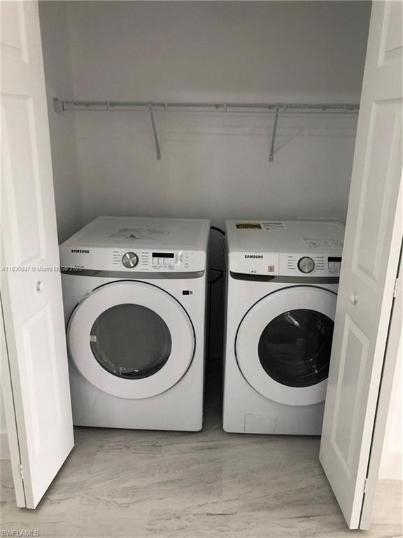 Laundry room featuring independent washer and dryer and light wood-style flooring