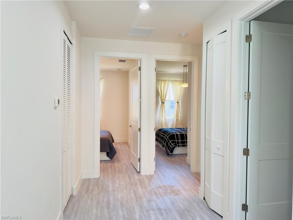 Hallway with light wood finished floors and recessed lighting