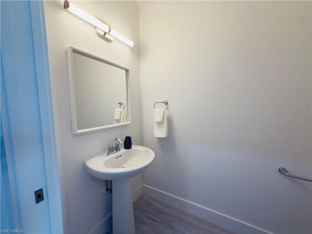 Bathroom with baseboards and dark wood-type flooring