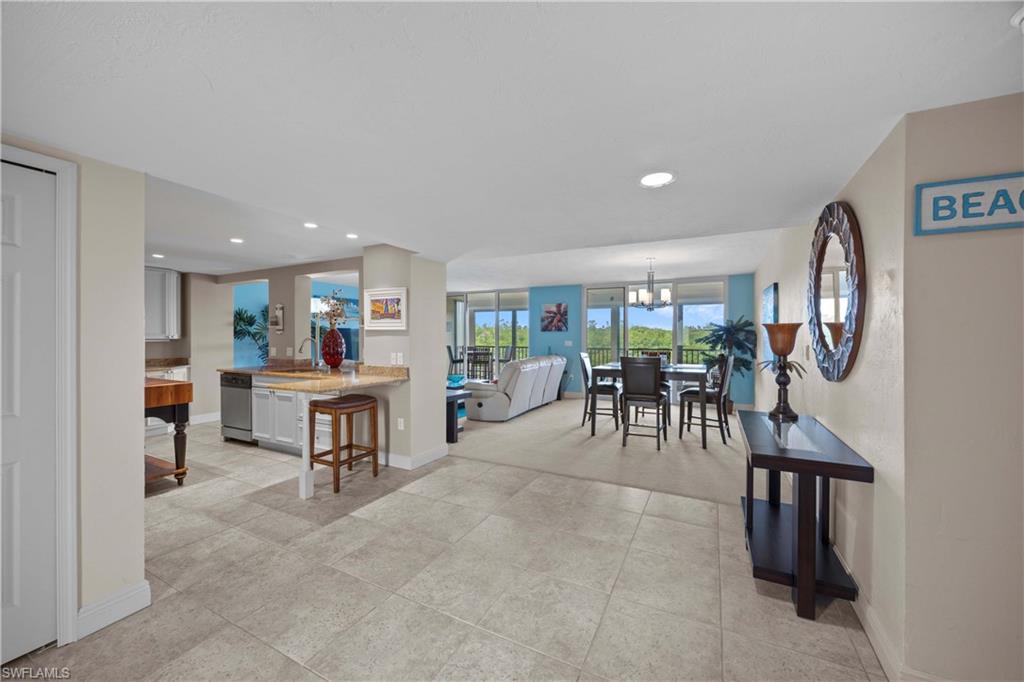 Tiled dining area featuring sink and a chandelier