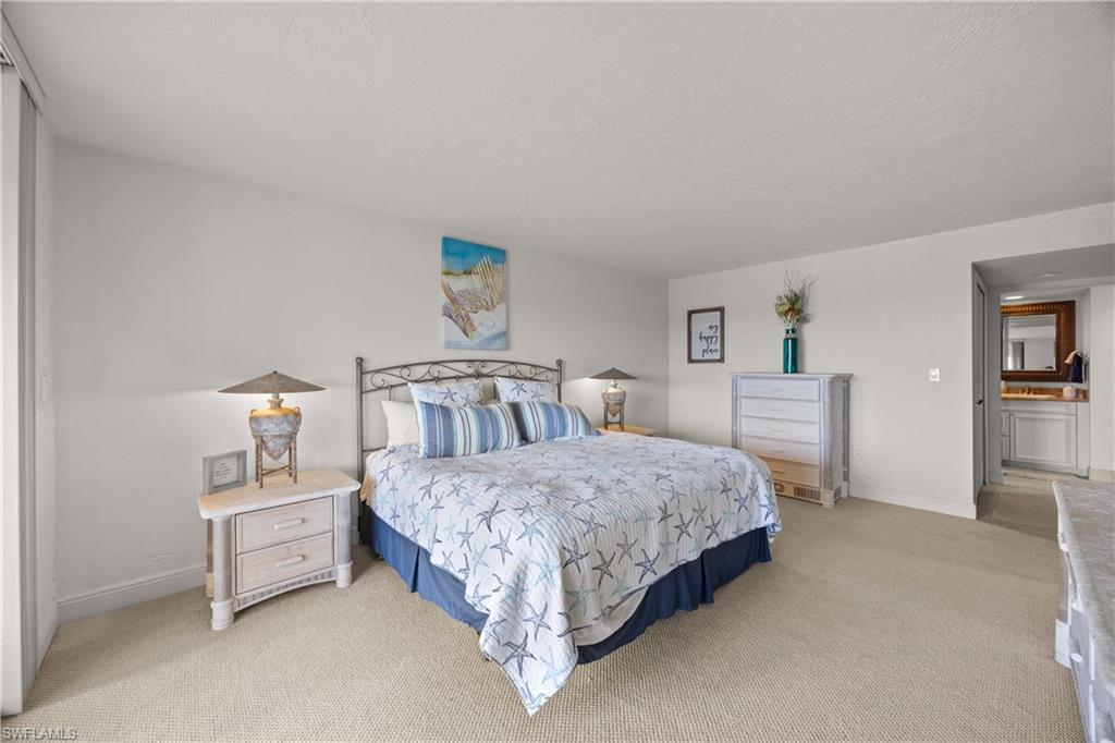 Bedroom featuring ensuite bath and light colored carpet