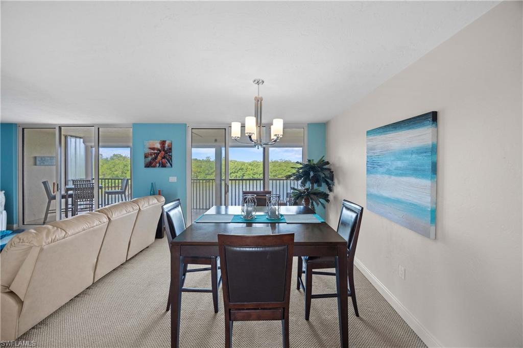 Carpeted dining space featuring a chandelier