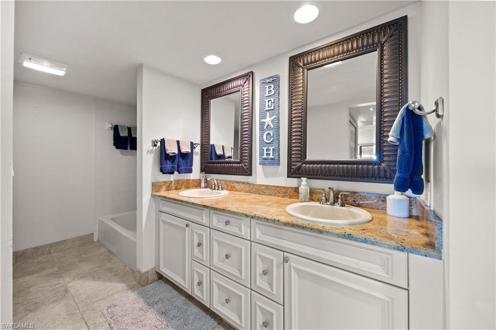 Bathroom featuring shower / bathing tub combination, tile patterned flooring, and vanity