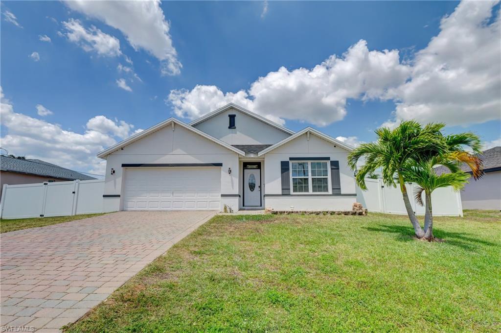 Single story home featuring stucco siding, decorative driveway, and a garage