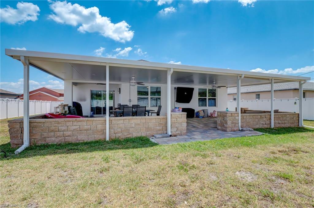 Back of house with a ceiling fan, a fenced backyard, and a patio