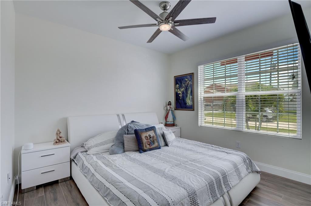 Bedroom with dark wood-type flooring and a ceiling fan