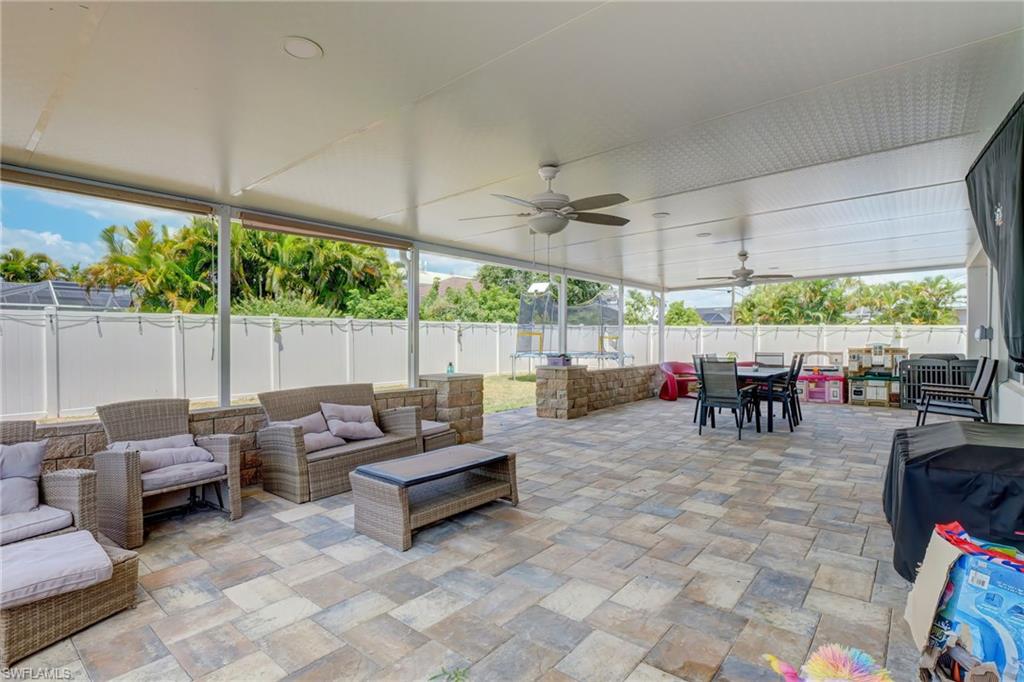 Fenced backyard featuring a ceiling fan, an outdoor living space, a patio, and outdoor dining space