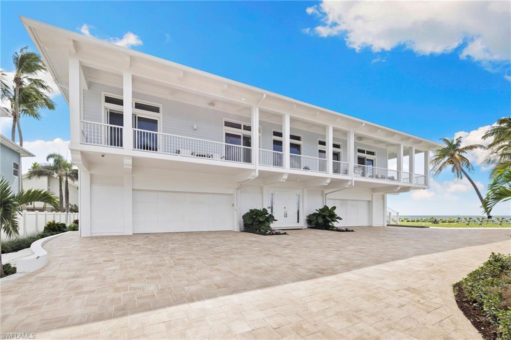 View of front of home with decorative driveway, a garage, and a balcony
