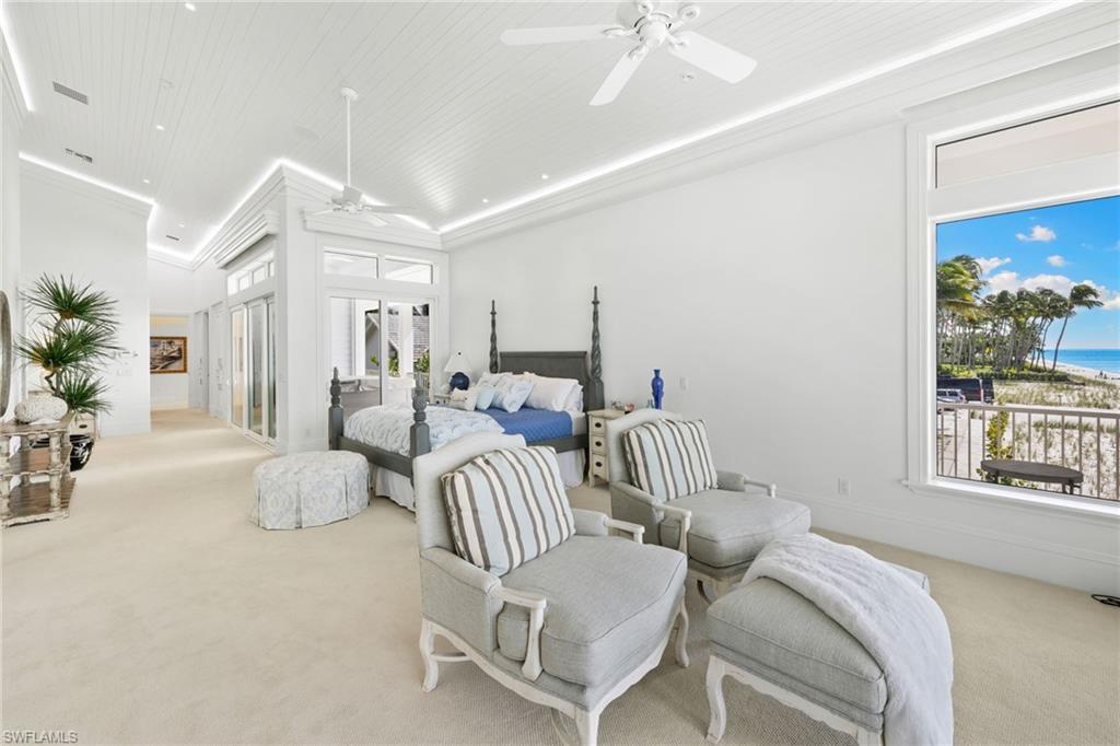 Bedroom featuring light colored carpet, multiple windows, and a water view