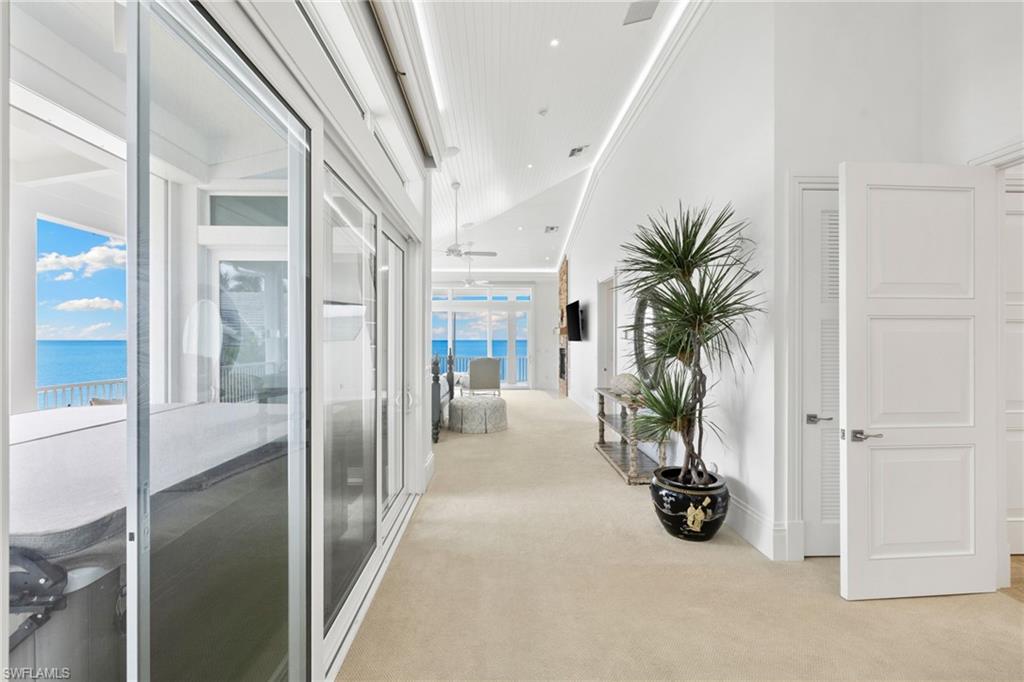 Hall featuring light carpet, a towering ceiling, and recessed lighting