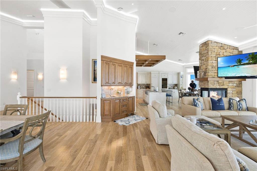 Living area featuring ornamental molding, light wood finished floors, and lofted ceiling