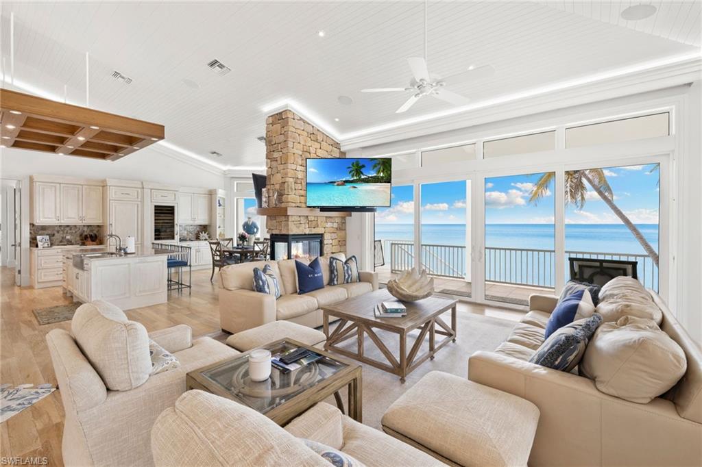 Living room with light wood-style floors, a stone fireplace, ceiling fan, wood ceiling, and recessed lighting