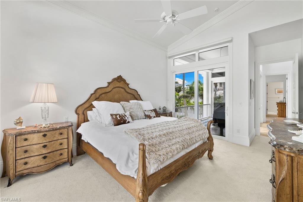 Bedroom with crown molding, vaulted ceiling, light colored carpet, access to exterior, and ceiling fan