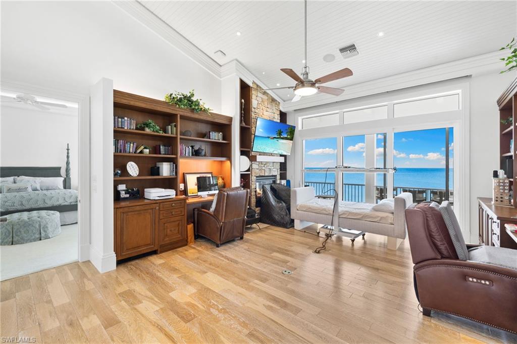 Home office featuring ceiling fan, a fireplace, light wood-style floors, recessed lighting, and ornamental molding