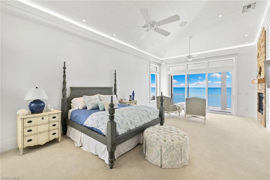 Bedroom with carpet flooring, ceiling fan, access to outside, a stone fireplace, and recessed lighting