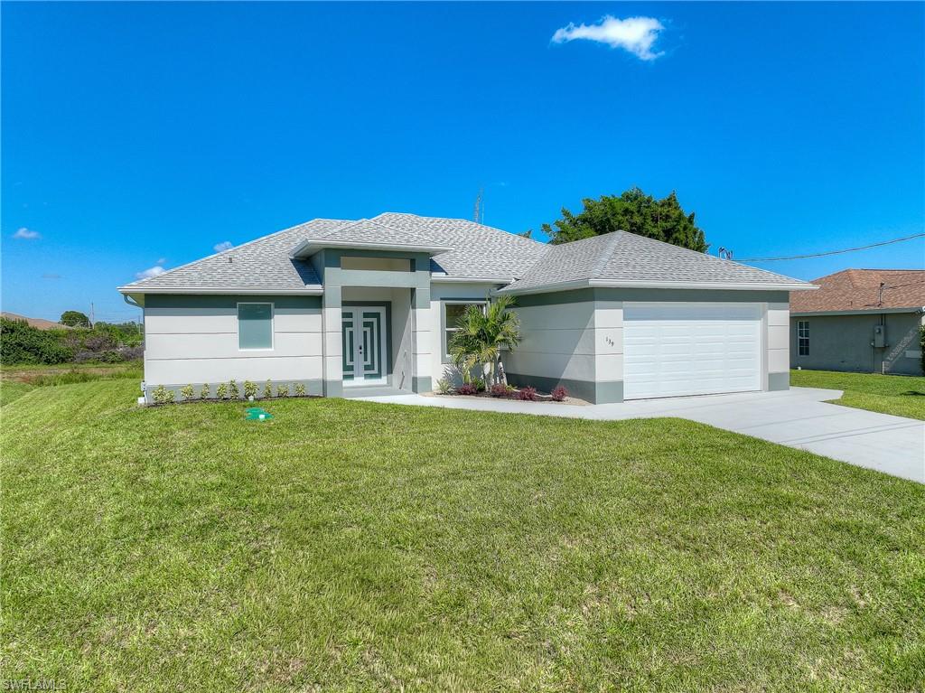 View of front of house featuring a front yard, a shingled roof, concrete driveway, a garage, and stucco siding