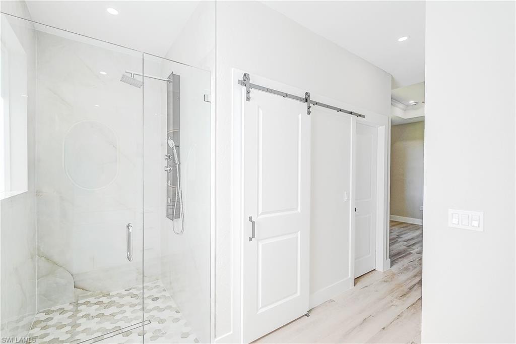 Primary room with recessed lighting, a tray ceiling, light wood finished floors, and a ceiling fan