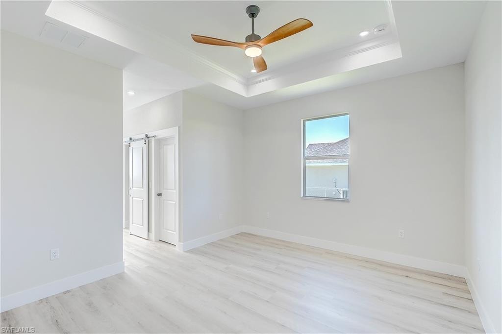 Den - Office with a ceiling fan, light wood finished floors, and vaulted ceiling