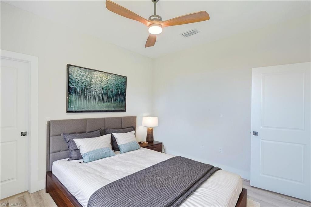 LVR - Kitchen view with a raised ceiling, appliances with stainless steel finishes, an open floor plan, white cabinetry, and a center island with sink