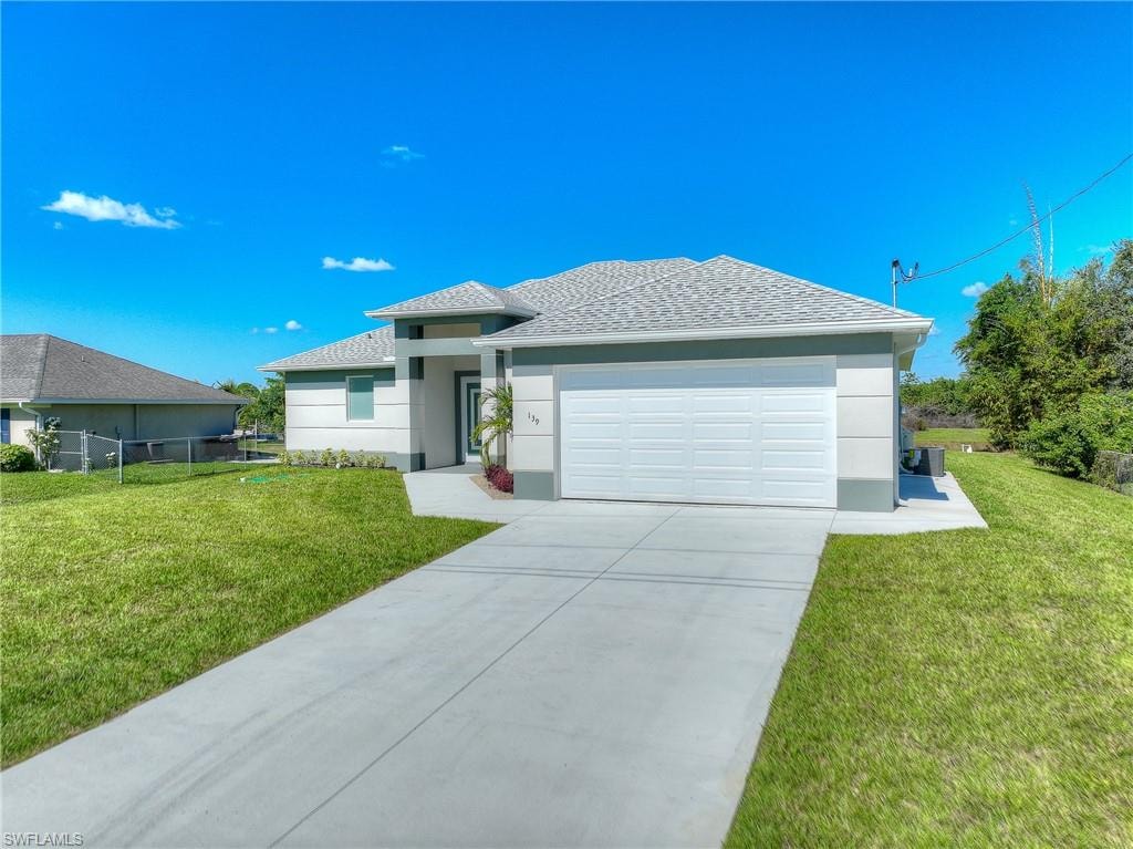 Prairie-style home featuring concrete driveway, a garage, stucco siding, and roof with shingles