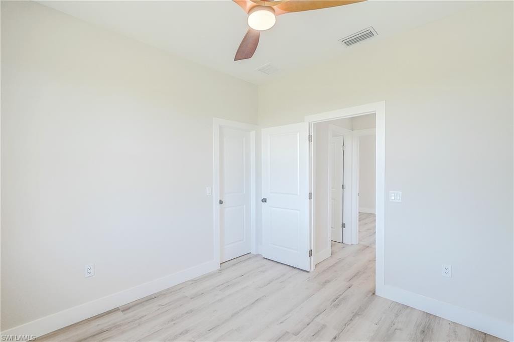 Unfurnished room featuring light wood-type flooring and a ceiling fan