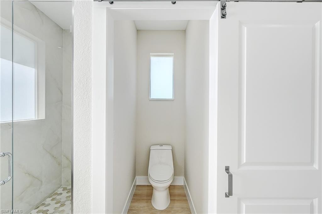 Empty room featuring a tray ceiling, light wood finished floors, a ceiling fan, crown molding, and recessed lighting