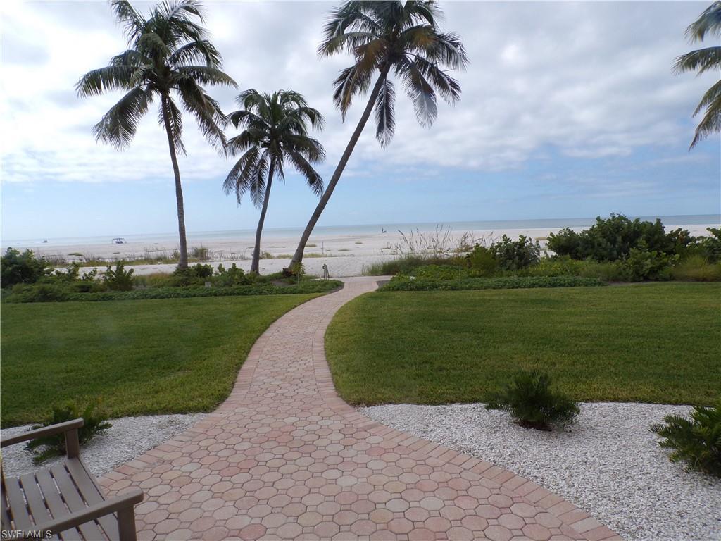 View of property's community with a water view and a lawn