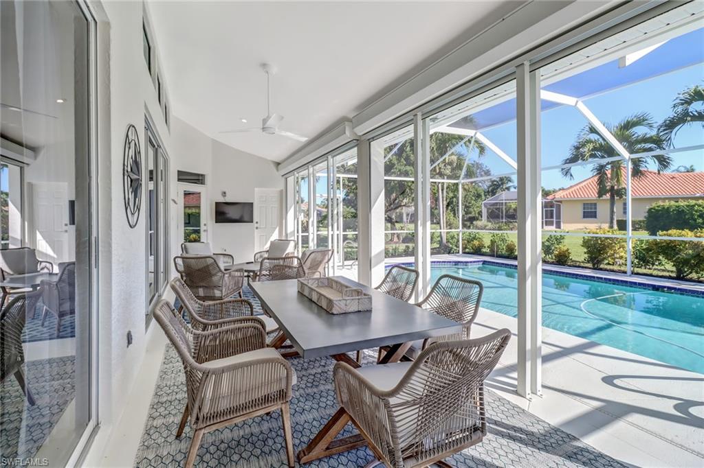 Sunroom with healthy amount of natural light, a swimming pool, and vaulted ceiling