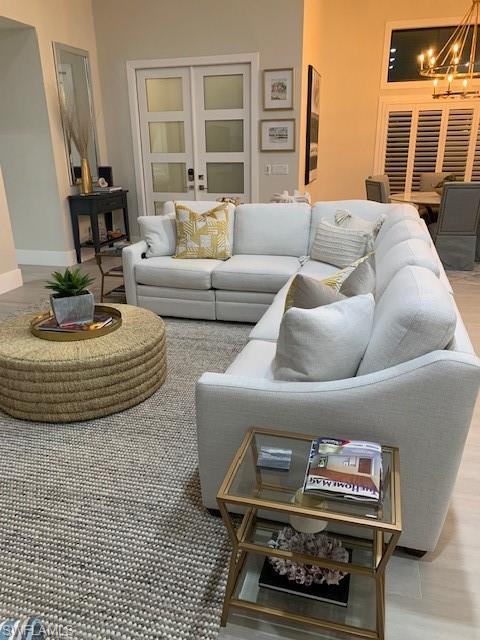 Living room featuring light wood-style floors and a chandelier