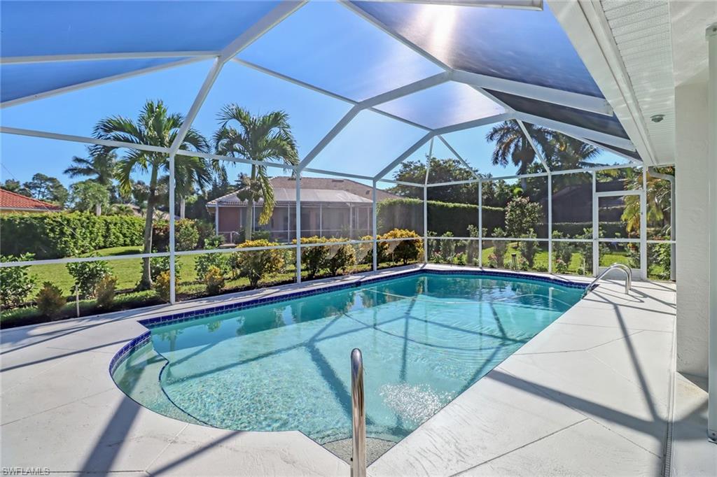 Outdoor pool featuring a sunroom, glass enclosure, and a patio