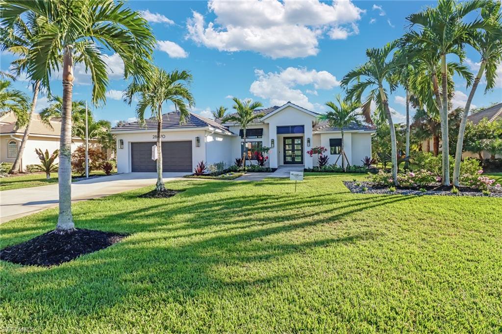 Single story home with concrete driveway, stucco siding, a front yard, and an attached garage