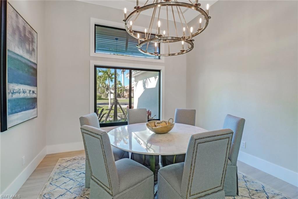 Dining area featuring light wood-style flooring and a towering ceiling