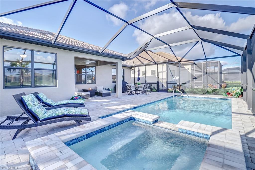 View of pool with a sunroom, a patio, a ceiling fan, a pool with connected hot tub, and a lanai