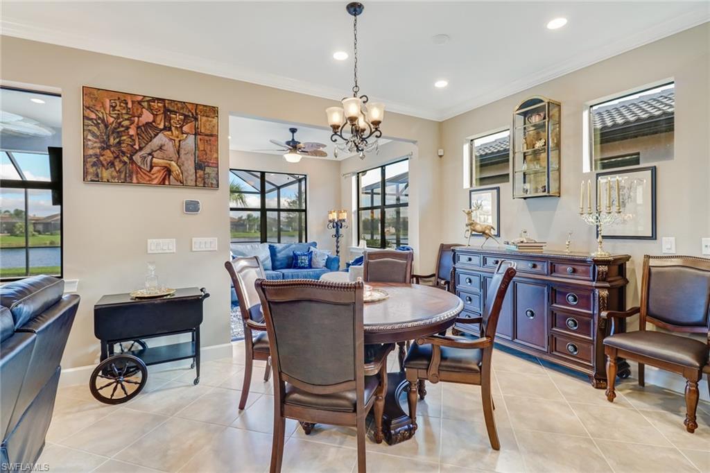 Dining space featuring ornamental molding, a chandelier, light tile patterned floors, a ceiling fan, and recessed lighting