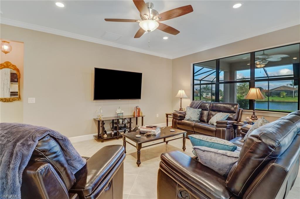 Living area with recessed lighting, ornamental molding, light tile patterned floors, and a ceiling fan