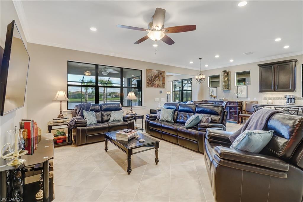 Living area with ornamental molding, a chandelier, light tile patterned flooring, recessed lighting, and a ceiling fan
