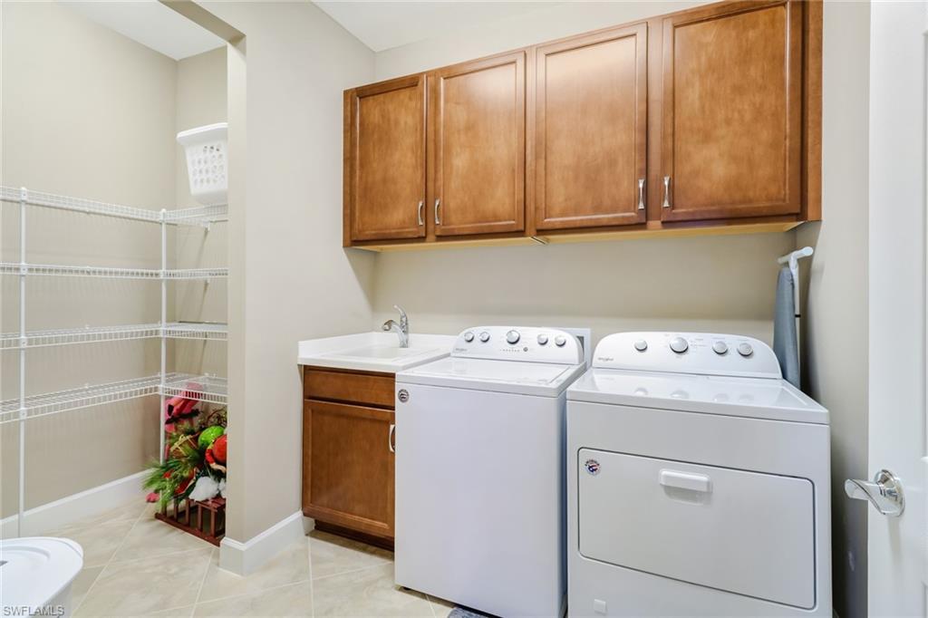 Laundry room featuring light tile patterned flooring, independent washer and dryer, and cabinet space