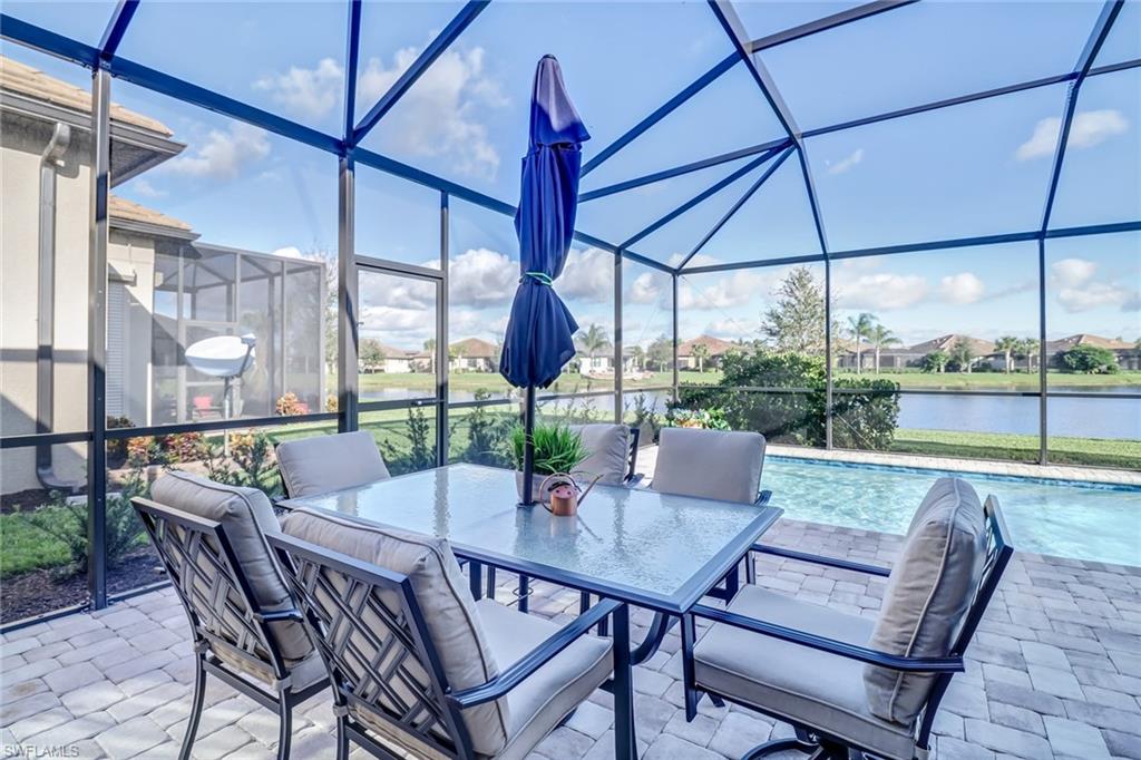 View of patio with glass enclosure, outdoor dining space, an outdoor pool, and a sunroom