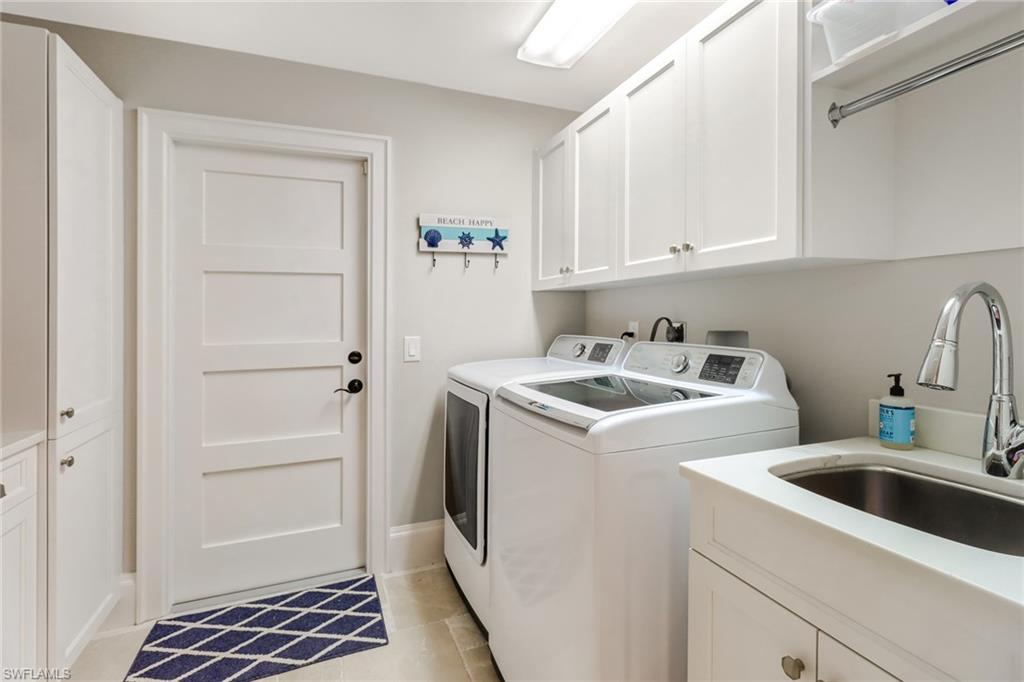 Laundry area featuring cabinet space, light tile patterned flooring, and independent washer and dryer