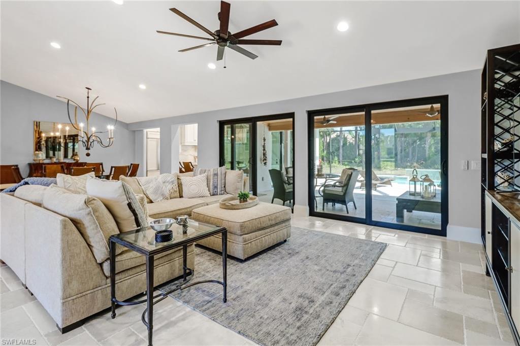 Living area featuring lofted ceiling, a chandelier, recessed lighting, and ceiling fan
