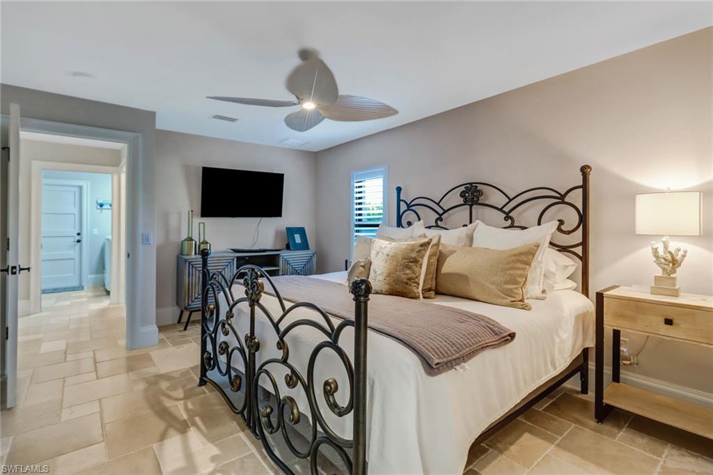 Bedroom featuring ceiling fan and stone tile flooring