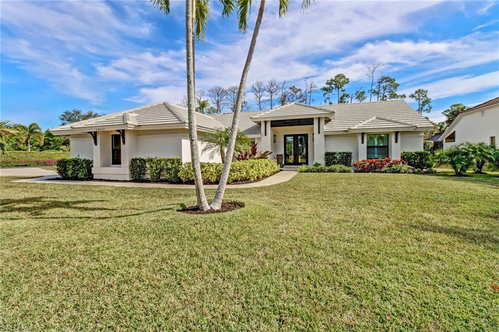 Prairie-style home featuring a front yard, stucco siding, and a tiled roof