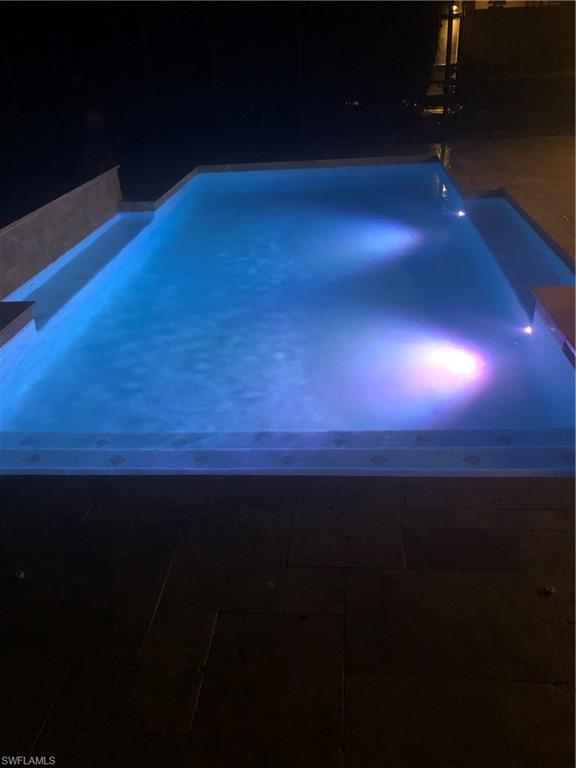 View of pool with a hot tub