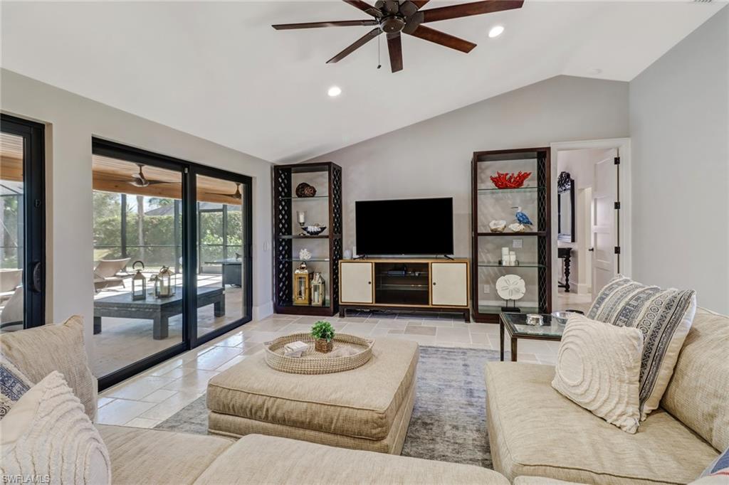 Living room with a ceiling fan, recessed lighting, vaulted ceiling, and stone tile flooring
