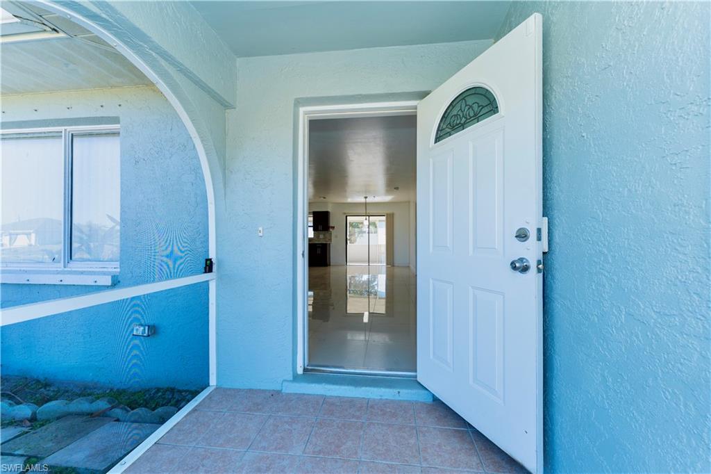Doorway to property featuring stucco siding