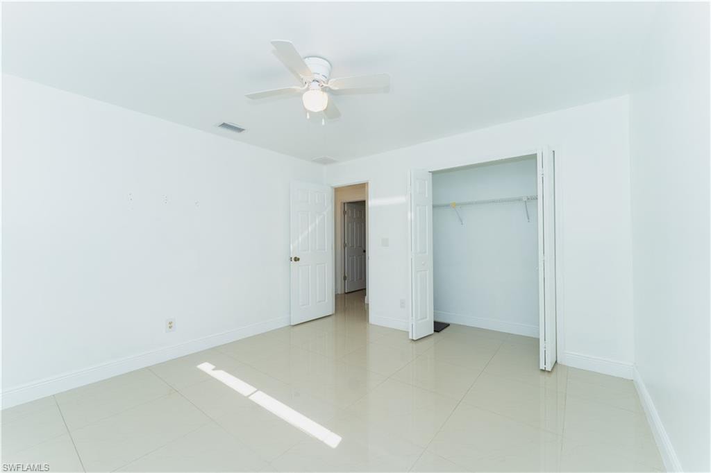 Unfurnished bedroom featuring ceiling fan, a closet, and light tile patterned floors