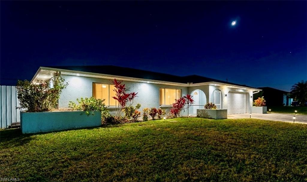 Ranch-style home with a lawn, concrete driveway, an attached garage, and stucco siding