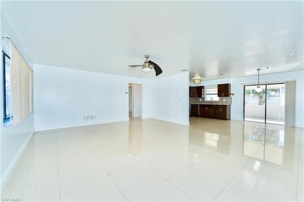 Unfurnished living room featuring a ceiling fan and light tile patterned floors